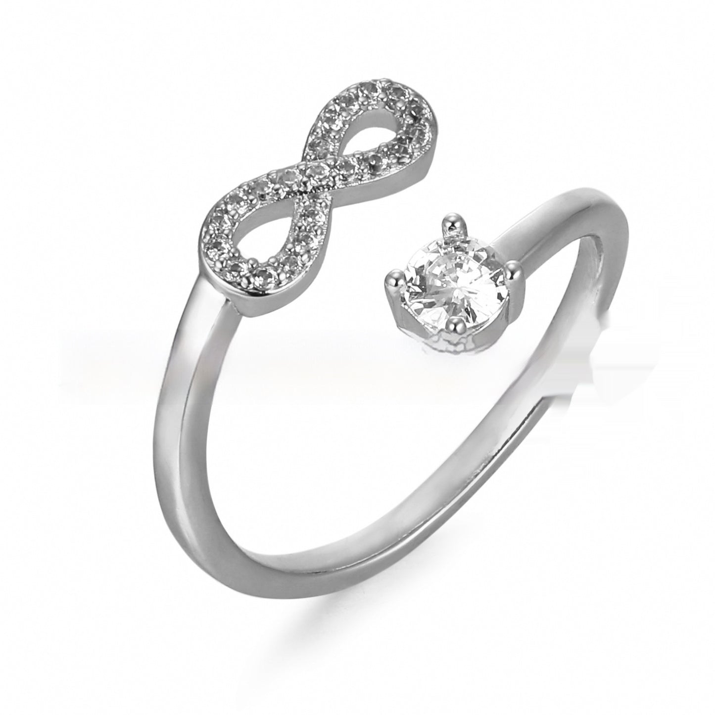 Silver ring with infinity symbol and heart-shaped gem on a white background