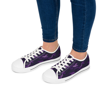 Purple camo sneakers with white accents worn with blue jeans on a white background