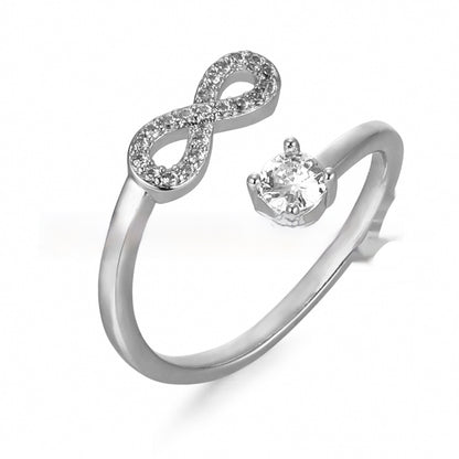 Silver ring with infinity symbol and heart-shaped gem on a white background
