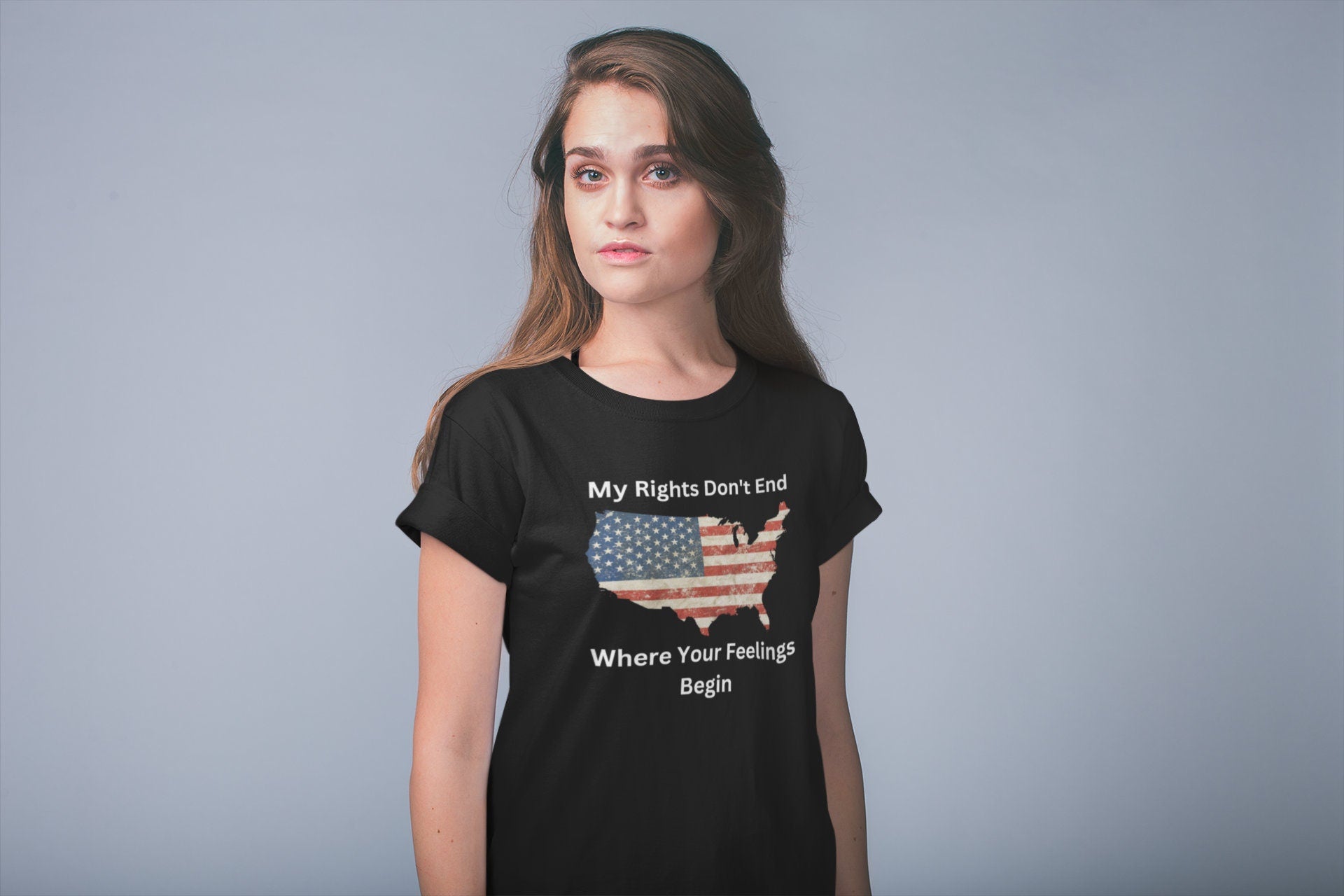 Unisex patriotic graphic t-shirt featuring a vintage American flag in the shape of the USA with the bold freedom quote &quot;My Rights Don&#39;t End Where Your Feelings Begin&quot; — ideal for conservative women, pro-constitution supporters, and American pride outfits. Modeled by a confident woman against a light background.