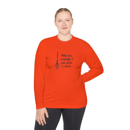 Woman wearing a bold orange long-sleeve Halloween shirt featuring a black broomstick illustration and the playful witch quote &quot;Why yes, actually, I can drive a stick!&quot; — ideal for spooky season fashion, Halloween parties, and fall festivities. Funny witch-themed shirt for women, perfect for October outfits, costume alternatives, and autumn lovers.