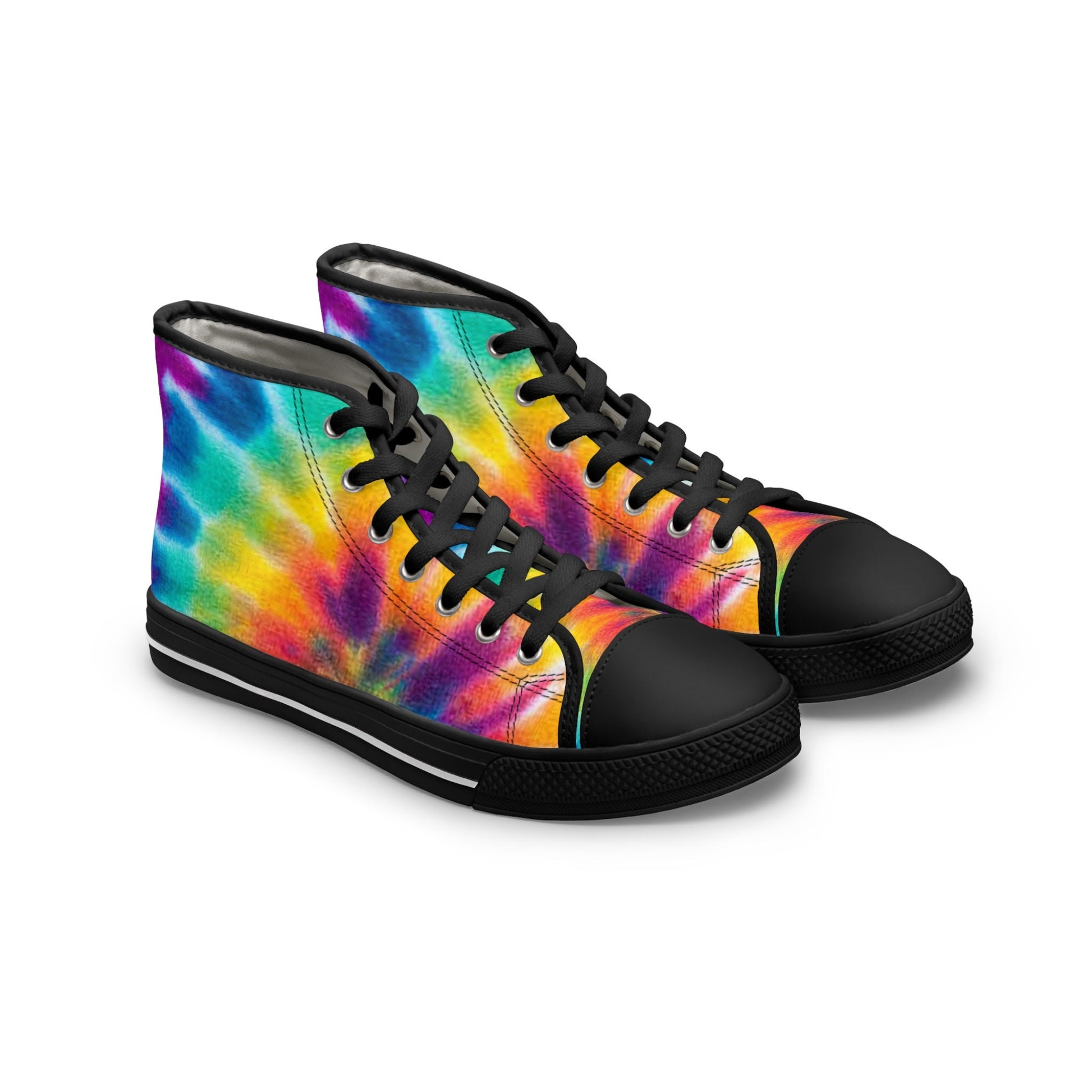 A pair of high-top sneakers is displayed on a white background. The shoes feature a bold and colorful rainbow tie-dye pattern in vibrant shades of red, orange, yellow, green, blue, and purple. They are designed with black laces, black rubber toe caps, and black soles with a white stripe, creating a striking contrast with the bright upper.