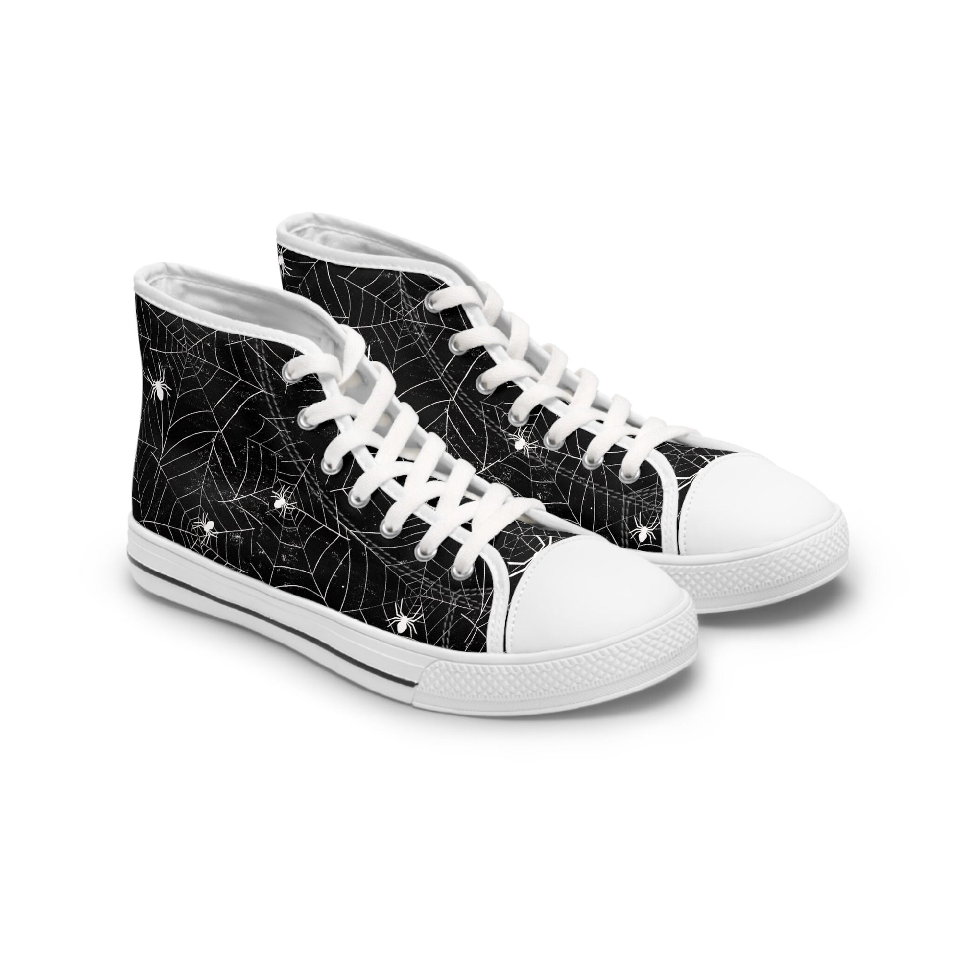 Pair of black high-top sneakers with white soles, toe caps, and laces. The canvas features a white spiderweb and spider pattern throughout, giving the shoes a Halloween-inspired design.