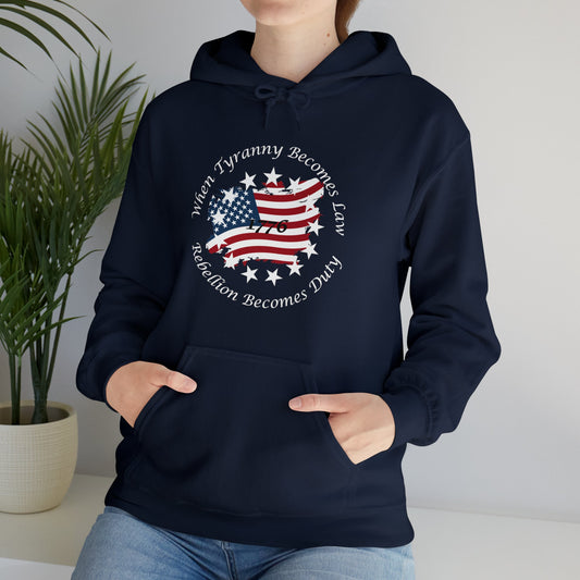 Black unisex patriotic hoodie with distressed American flag and “When Tyranny Becomes Law, Rebellion Becomes Duty” quote, worn by woman indoors. 1776 freedom statement sweatshirt for men and women, bold conservative apparel, pro-America pullover hoodie. Great gift for patriots, political activists, or USA pride clothing.
