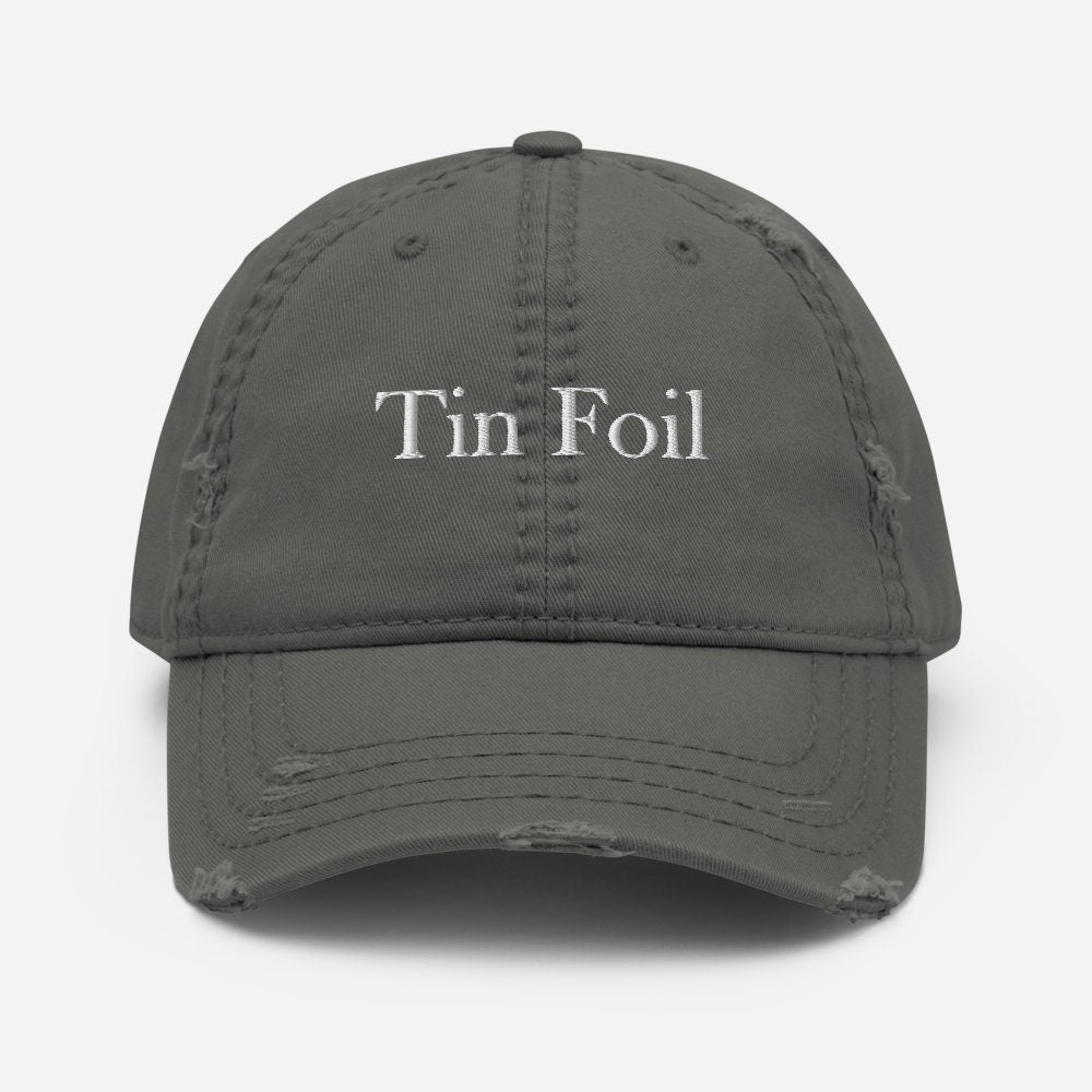 A gray distressed baseball cap with the words &quot;Tin Foil&quot; embroidered in white on the front. The cap features frayed detailing and worn patches on the brim and crown seams, giving it a vintage, well-loved appearance. It is shown against a clean white background, centered and facing forward.