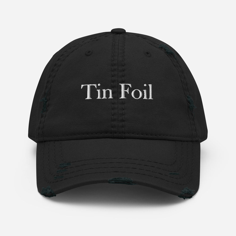 A black distressed baseball cap with the words &quot;Tin Foil&quot; embroidered in white on the front. The hat features intentional fraying and worn details along the brim and crown seams, giving it a vintage, rugged look. The cap is displayed against a plain white background, centered and facing forward.
