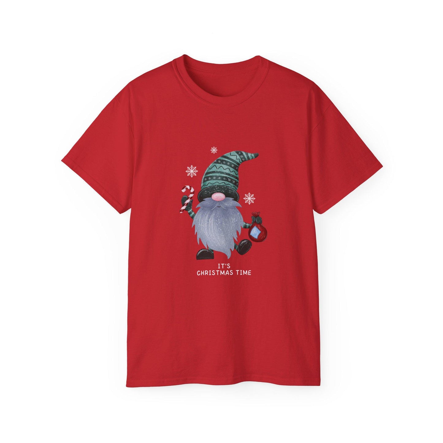 A red unisex T-shirt is displayed against a white background, featuring a festive graphic of a Christmas gnome with a long gray beard, wearing a green patterned hat. The gnome is holding a candy cane and a red ornament, surrounded by white snowflakes. Below the illustration, the text &quot;It&#39;s Christmas Time&quot; is printed in white. The shirt has a classic crew neck and short sleeves.