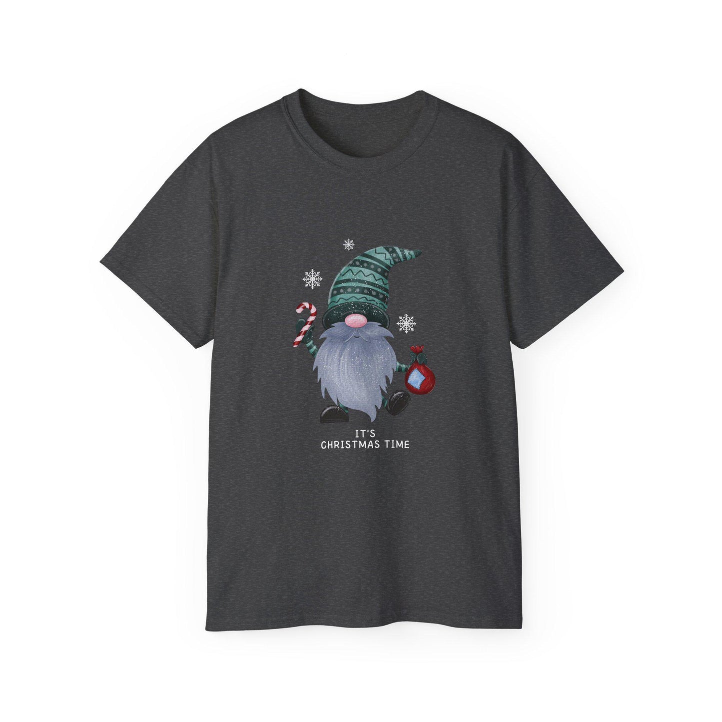 A dark heather gray unisex T-shirt is displayed against a white background, featuring a playful Christmas gnome graphic. The gnome has a long gray beard, a pink nose, and is wearing a green patterned hat. He holds a red and white candy cane in one hand and a red ornament in the other, surrounded by white snowflakes. Below the design, the phrase &quot;It&#39;s Christmas Time&quot; is printed in white. The shirt has a classic crew neck and short sleeves.