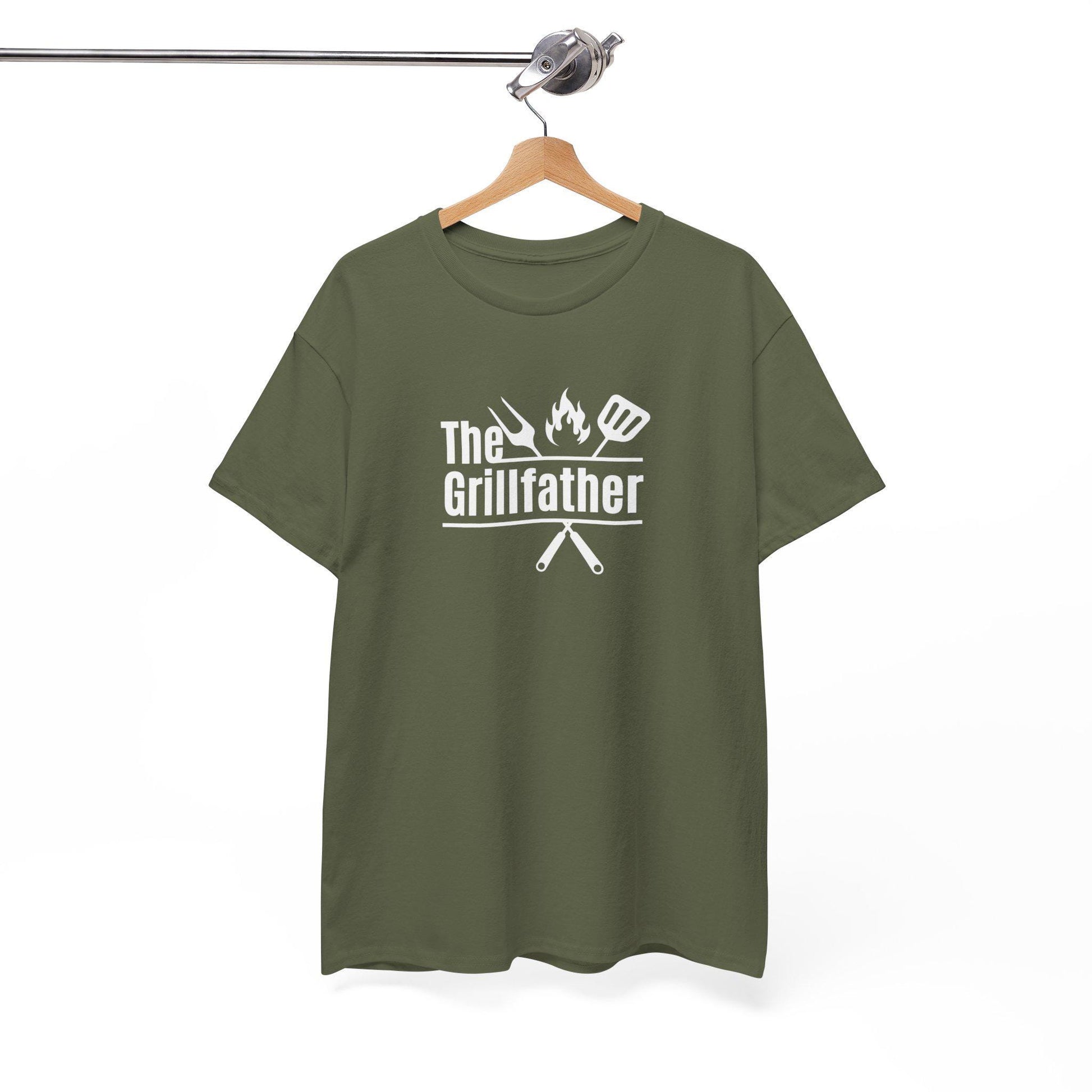 Olive green T-shirt on a wooden hanger with the phrase “The Grillfather” in white text, featuring grilling icons including a fork, flame, and spatula above crossed utensils, displayed against a plain background.