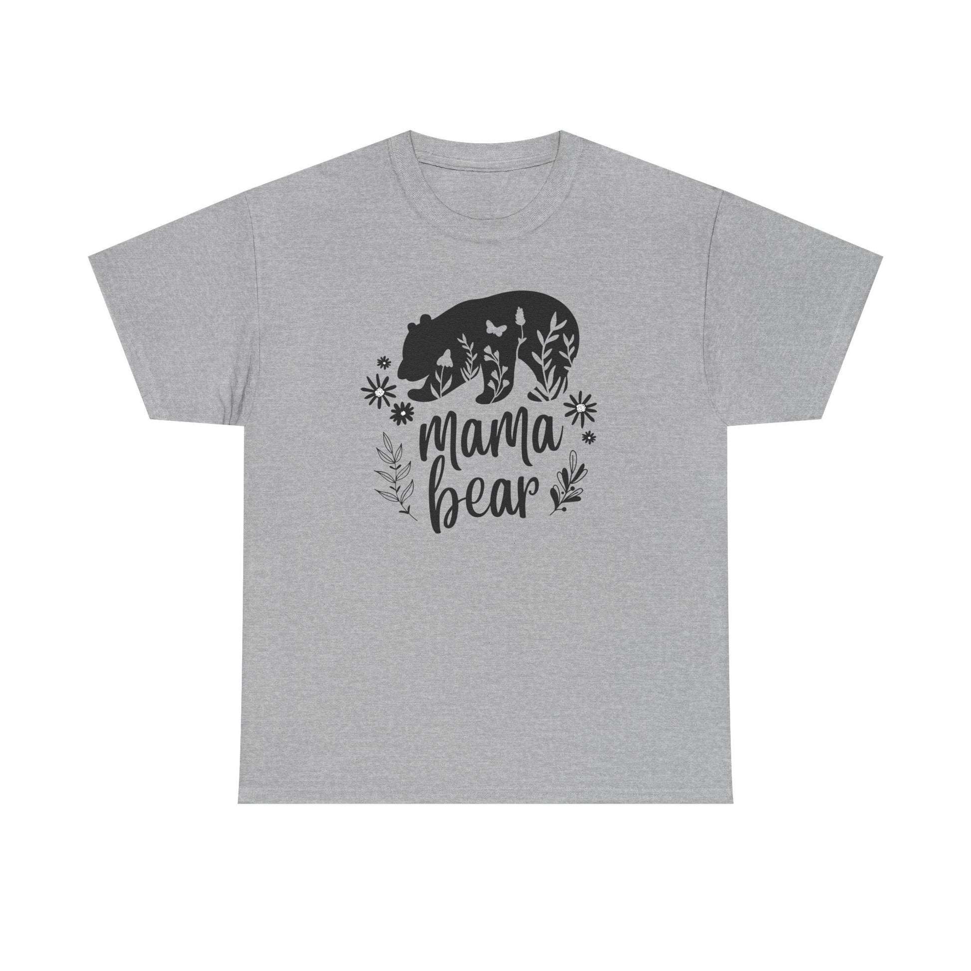 Beige t-shirt laid flat on a white background, featuring a bold black &#39;Mama Bear&#39; graphic. The design includes a silhouette of a bear filled with floral and butterfly elements, with the words &#39;mama bear&#39; written below and surrounded by decorative leaves and flowers.