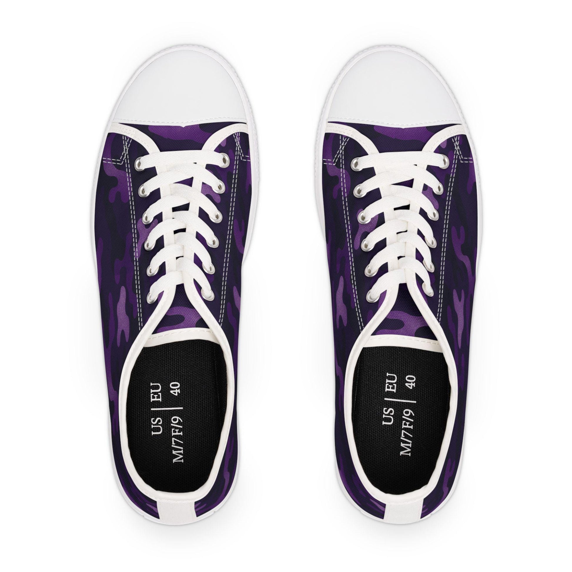 Top view of a pair of low-top canvas sneakers with a purple camouflage pattern, white rubber toe caps, and white laces. The insoles are black and printed with size details showing US M7/F9 and EU 40.