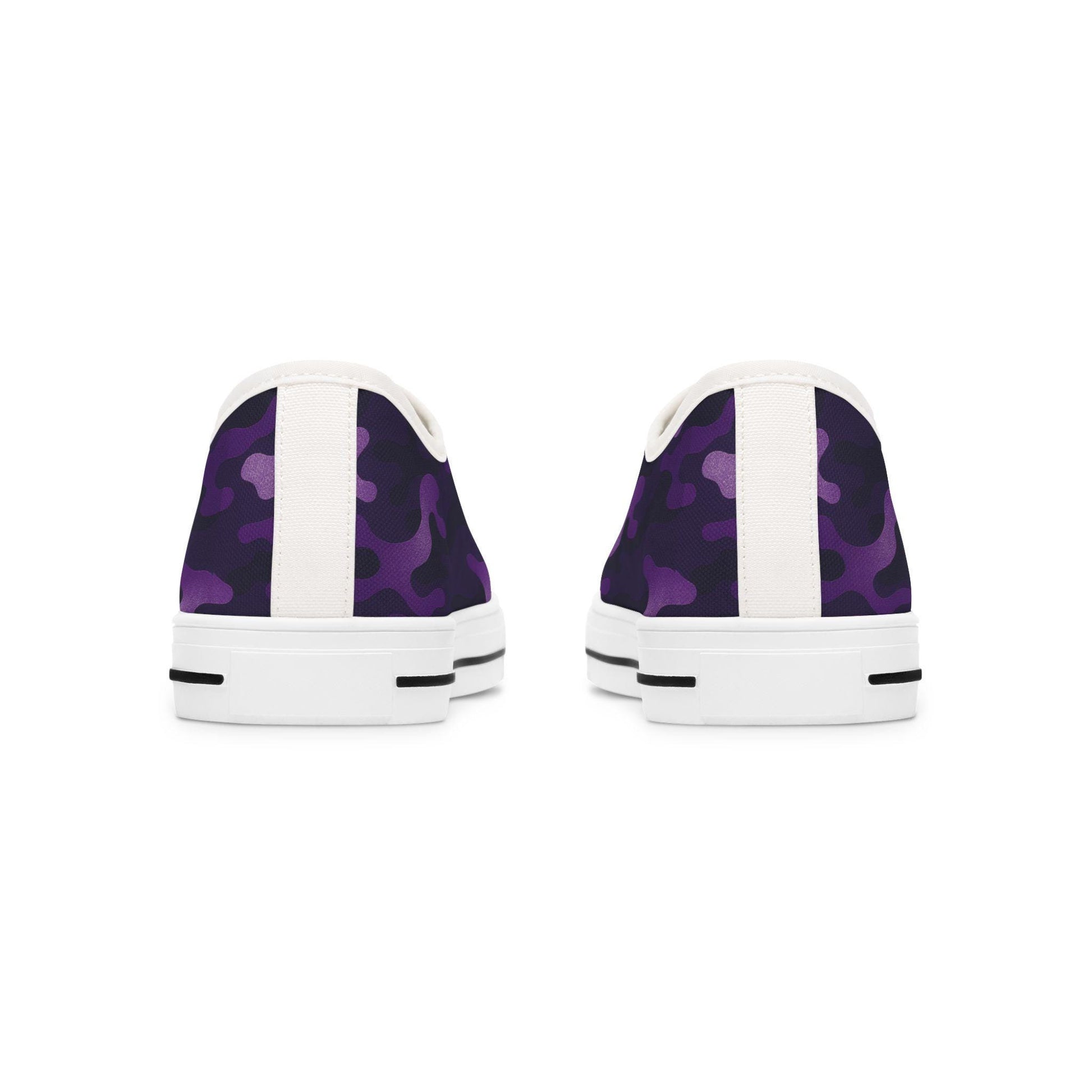 Rear view of a pair of low-top canvas sneakers featuring a purple camouflage pattern with white heel tabs and white rubber soles. The soles include black stripe accents near the back for added detail.
