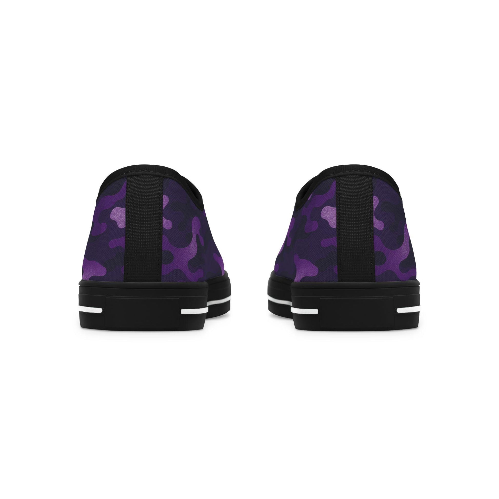 Rear view of a pair of low-top canvas sneakers featuring a purple camouflage pattern with black heel tabs and black rubber soles. The soles are accented with horizontal white stripes near the back.