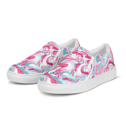 A pair of slip-on sneakers with a bold marbled swirl design in pink, teal, and white. The shoes have white elastic side panels and white rubber soles, and are displayed on a clean white background at a slight angle to showcase both the front and side views.