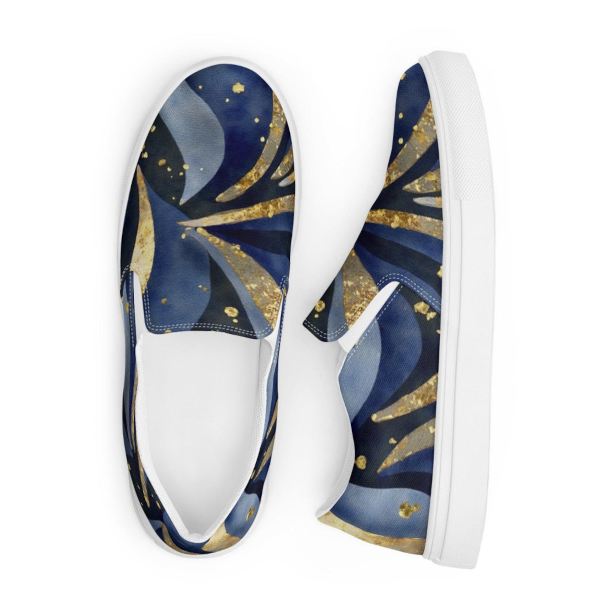 Top-down view of a pair of slip-on sneakers featuring a vibrant celestial-themed design with swirling deep blue, black, and gold patterns resembling stars and cosmic waves. The shoes have white soles and interior lining, emphasizing the bold and artistic upper design. Displayed against a plain white background, the sneakers are positioned with one shoe facing up and the other turned sideways.