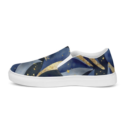 A side view of a slip-on sneaker showcasing a celestial-themed design with flowing deep blue, black, and gold patterns resembling cosmic waves and stars. The shoe features a clean white sole, white inner lining, and elastic side accents for easy wearing. Set against a plain white background, the vibrant and artistic design stands out prominently.