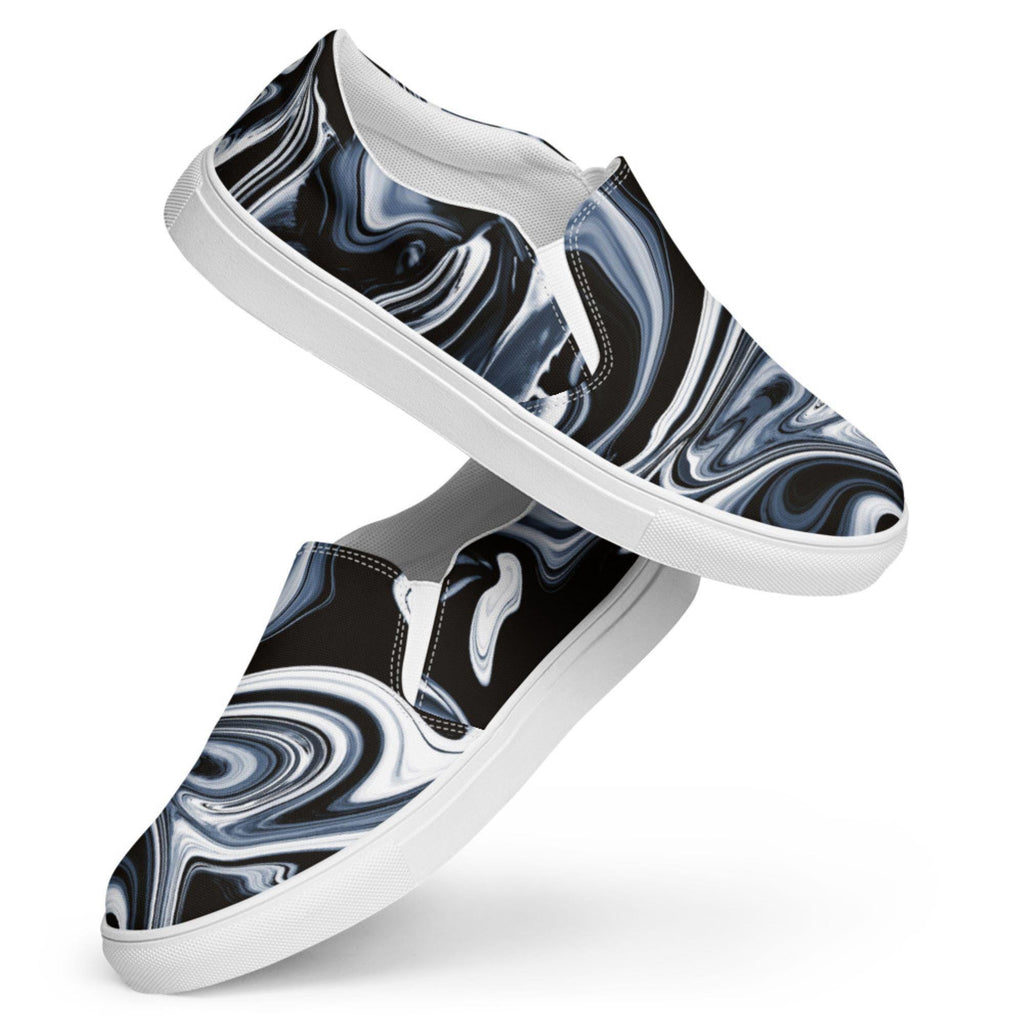 Stylish women’s slip-on canvas shoes with a black, white, and gray marbled swirl pattern, shown in a dynamic floating display with white soles and elastic side panels. Trendy and comfortable casual sneakers, perfect for everyday wear.