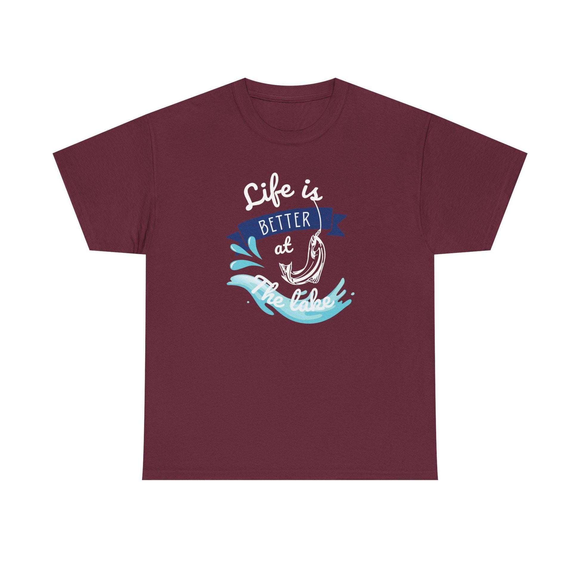 Flat lay of a maroon unisex t-shirt featuring a vibrant graphic design with the phrase &#39;Life is Better at the Lake.&#39; The design includes a fish hook, blue water splashes, and a navy banner, printed in white, blue, and aqua colors on a plain background.