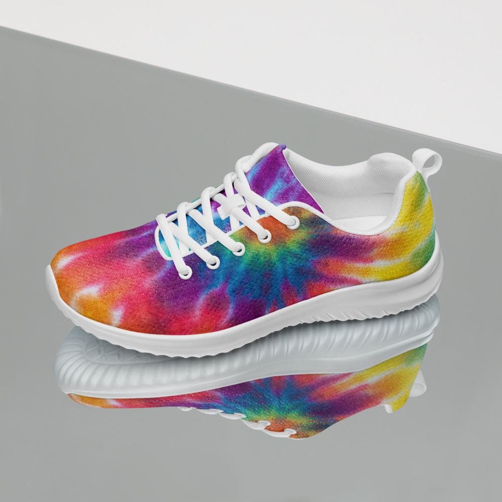 Single rainbow tie-dye athletic sneaker with white laces and cushioned sole, displayed on a reflective surface—stylish, lightweight, and ideal for active or casual wear.