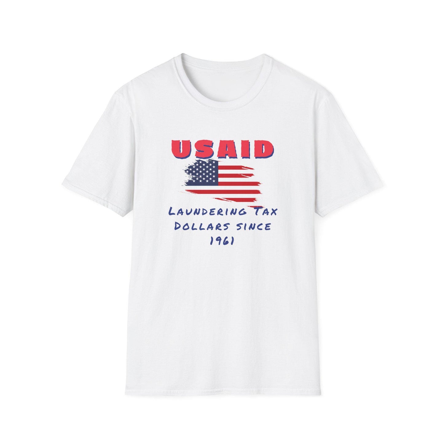 A white T-shirt is laid flat on a white background. The shirt features a bold, distressed American flag graphic in the center. Above the flag, large red block letters spell out &quot;USAID.&quot; Beneath the flag, blue handwritten-style text reads: &quot;Laundering Tax Dollars Since 1961.&quot; The design delivers a satirical political message with a vintage protest-inspired aesthetic.