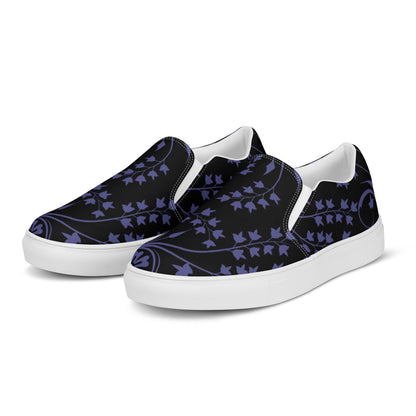 Pair of slip-on sneakers with a black canvas upper featuring a deep purple ivy vine pattern. The shoes have white soles, elastic side accents for easy wear, and a clean, minimal design ideal for casual and stylish everyday outfits.