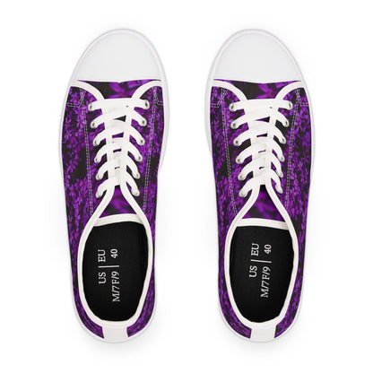 Top view of a pair of low-top sneakers featuring a vibrant purple floral pattern on a dark background. The shoes have white laces, white rubber toe caps, and white trim. The black insoles are printed with size information: US M7/F9 and EU 40. The clean design creates a bold contrast that highlights the colorful pattern.
