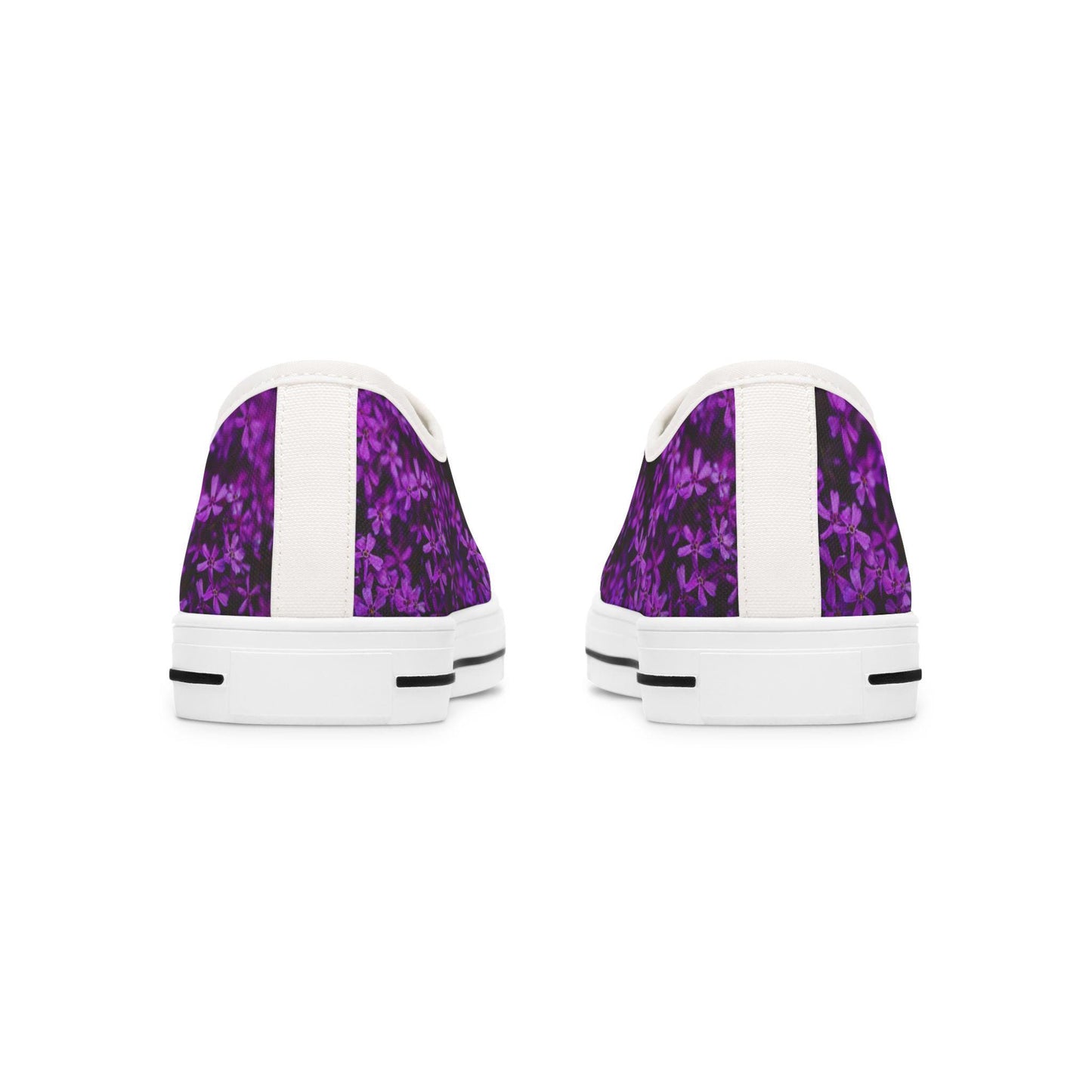 Rear view of a pair of low-top sneakers featuring a vibrant purple floral pattern on a dark background. Each shoe has a vertical white strip running down the back, complementing the white soles with black accent lines. The design creates a clean and modern contrast with the bold, colorful upper.