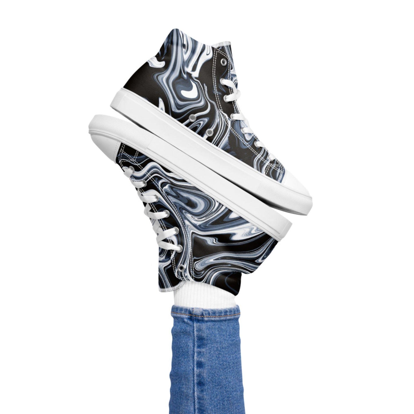 Playful image of a person lifting both legs while wearing high-top sneakers with a black, white, and blue marble swirl design. The shoes feature white laces and soles, paired with white socks and blue skinny jeans, set against a plain white background.