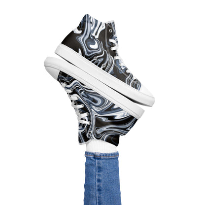 Playful image of a person lifting both legs while wearing high-top sneakers with a black, white, and blue marble swirl design. The shoes feature white laces and soles, paired with white socks and blue skinny jeans, set against a plain white background.