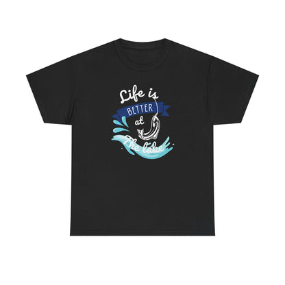 Flat lay of a black unisex t-shirt featuring a colorful graphic design with the phrase &#39;Life is Better at the Lake.&#39; The design includes a fishing hook, water splashes, and a blue banner, combining white, blue, and aqua tones, displayed on a plain white background.