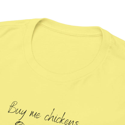 Close-up image of the neckline and upper chest area of a light yellow T-shirt. The shirt features a cleanly stitched crew neck and part of a printed design with the text &quot;Buy me chickens&quot; visible in black script. The fabric appears soft and smooth, showcasing quality construction.