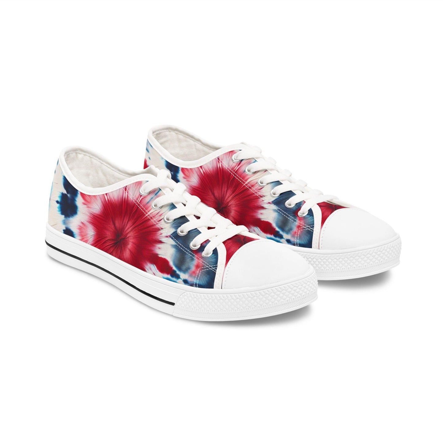 A pair of low-top canvas sneakers featuring a vibrant red, white, and blue tie-dye design. The shoes have white laces, white rubber soles with a textured toe cap, and a classic black stripe along the sole. The bold patriotic color scheme makes them perfect for summer events like the Fourth of July or casual everyday wear.