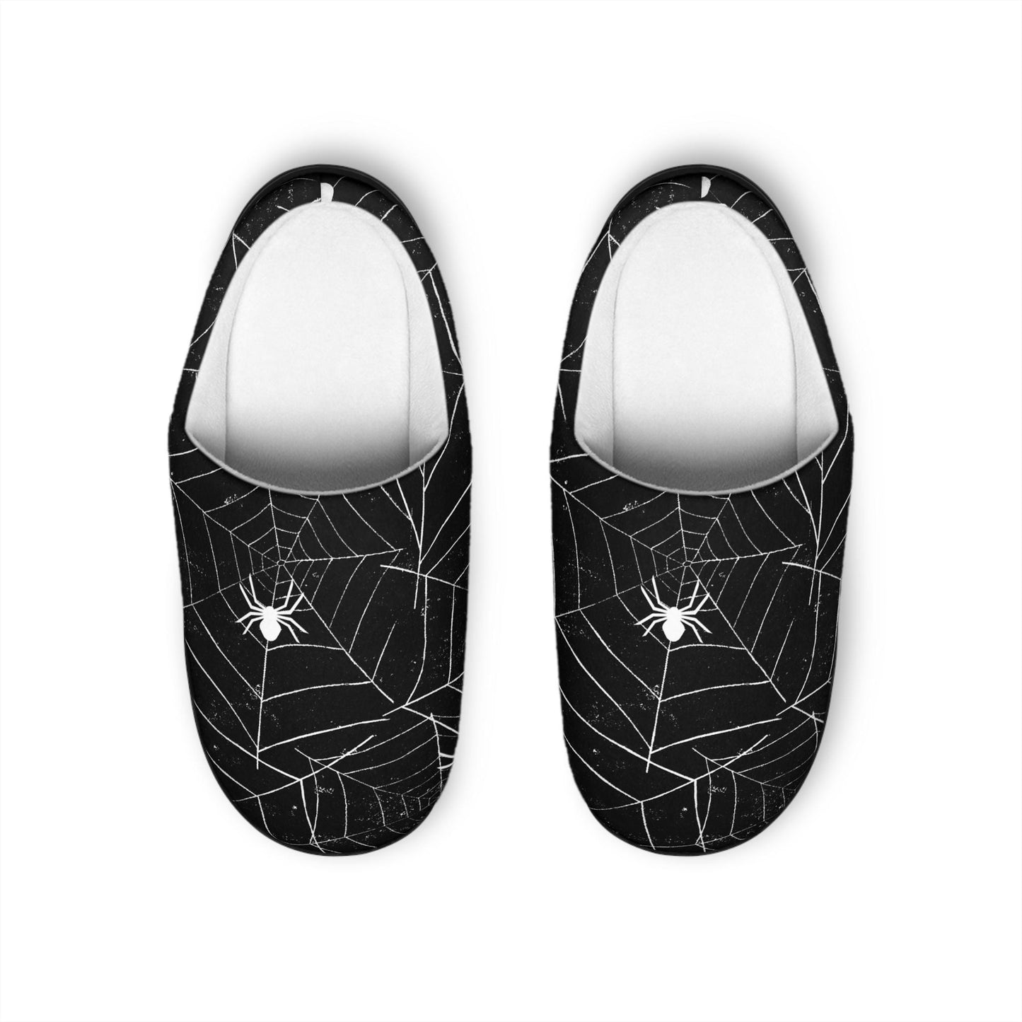 A pair of black slippers with white spiderweb and spider designs are displayed on a plain white background. The slippers have a cozy white interior lining and a sleek Halloween-inspired aesthetic, featuring symmetrical web patterns and a centered spider on each toe.