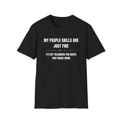 Black unisex T-shirt displayed on a white background with bold white and gold text that reads: “MY PEOPLE SKILLS ARE JUST FINE — IT’S MY TOLERANCE FOR IDIOTS THAT NEEDS WORK.” The design features a minimalist divider with small decorative elements between the two lines of text.