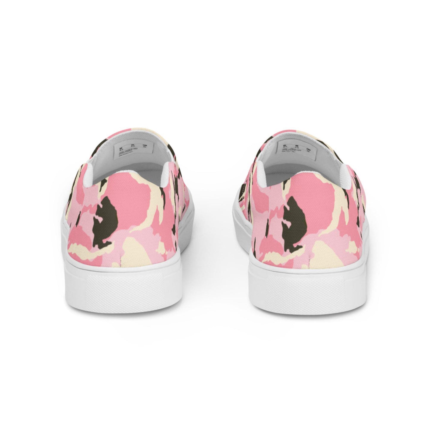 Rear view of a pair of slip-on sneakers featuring a pink camouflage pattern with cream and black accents, set against a white background, showcasing the back heel design and white rubber soles.