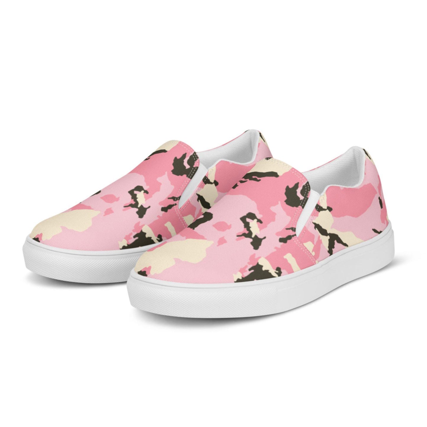 Pair of slip-on canvas sneakers featuring a bold pink camouflage pattern with cream and black accents, white elastic side panels, and white rubber soles, displayed on a white background.