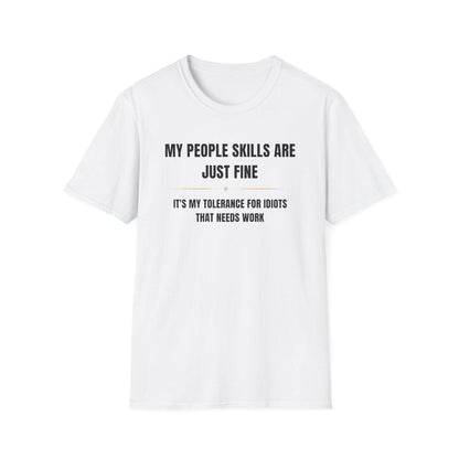 White unisex T-shirt displayed flat against a white background, featuring bold black and gray text that reads: “MY PEOPLE SKILLS ARE JUST FINE” above a small gray diamond and a thin orange line, followed by “IT’S MY TOLERANCE FOR IDIOTS THAT NEEDS WORK” in all caps.