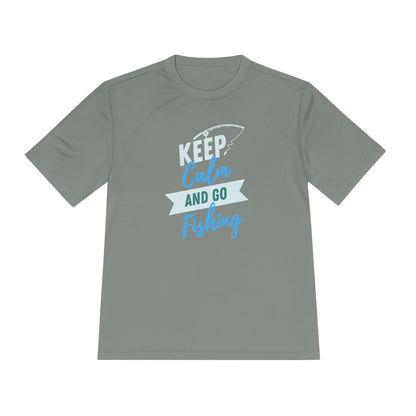Flat lay of a sage green T-shirt with a playful fishing-themed design. The graphic features the text “KEEP Calm AND GO Fishing” in a mix of white, teal, and blue fonts, accompanied by a fishing rod illustration above the word “KEEP.” Displayed on a clean white background, the shirt has a relaxed, unisex fit ideal for outdoor or casual wear.
