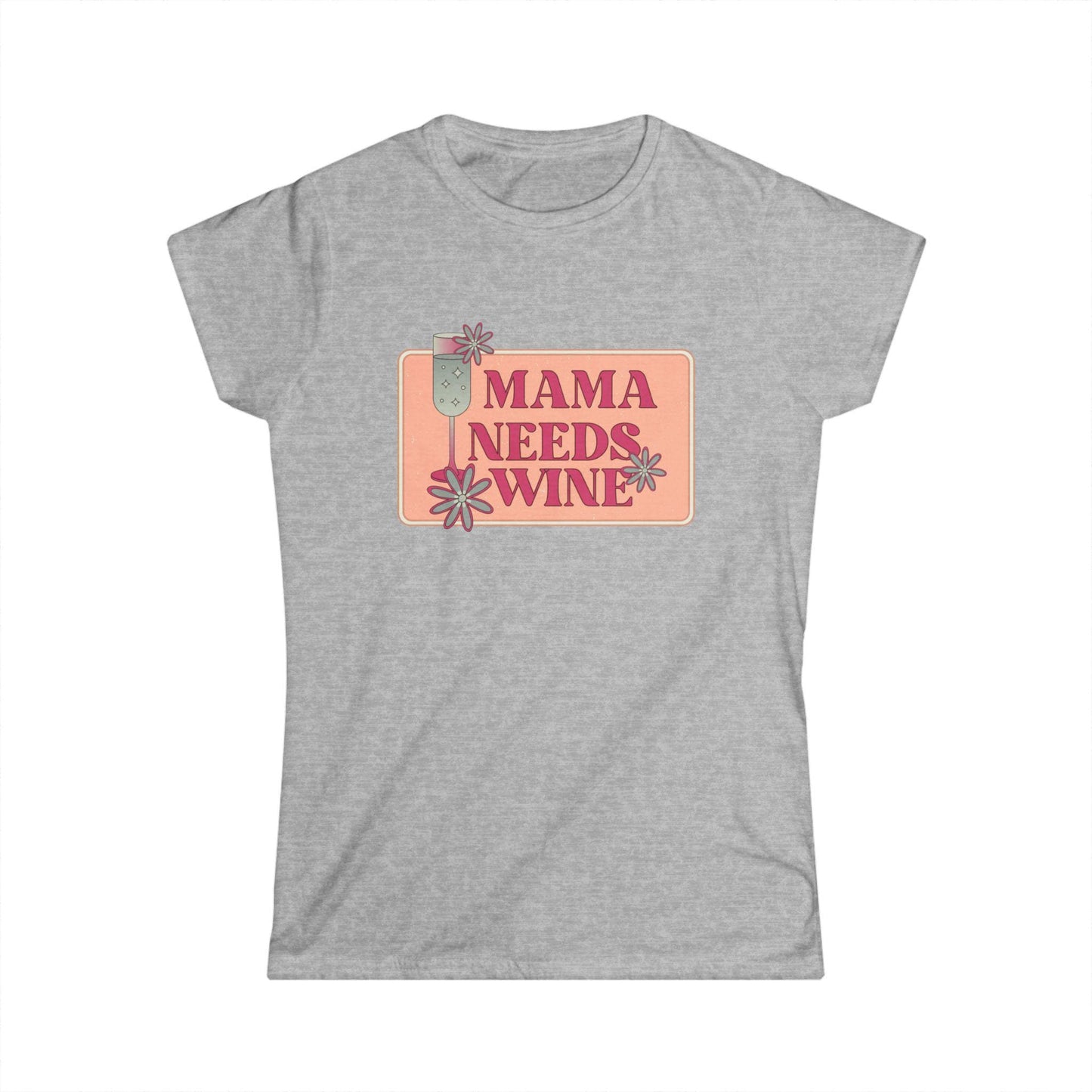 Front view of a heather gray women&#39;s fitted t-shirt with a playful graphic design that reads &quot;Mama Needs Wine&quot; in bold pink lettering. The design features a champagne glass and whimsical flowers in soft pastel tones, centered on a peach-colored rectangular background. The shirt is laid flat against a white backdrop.